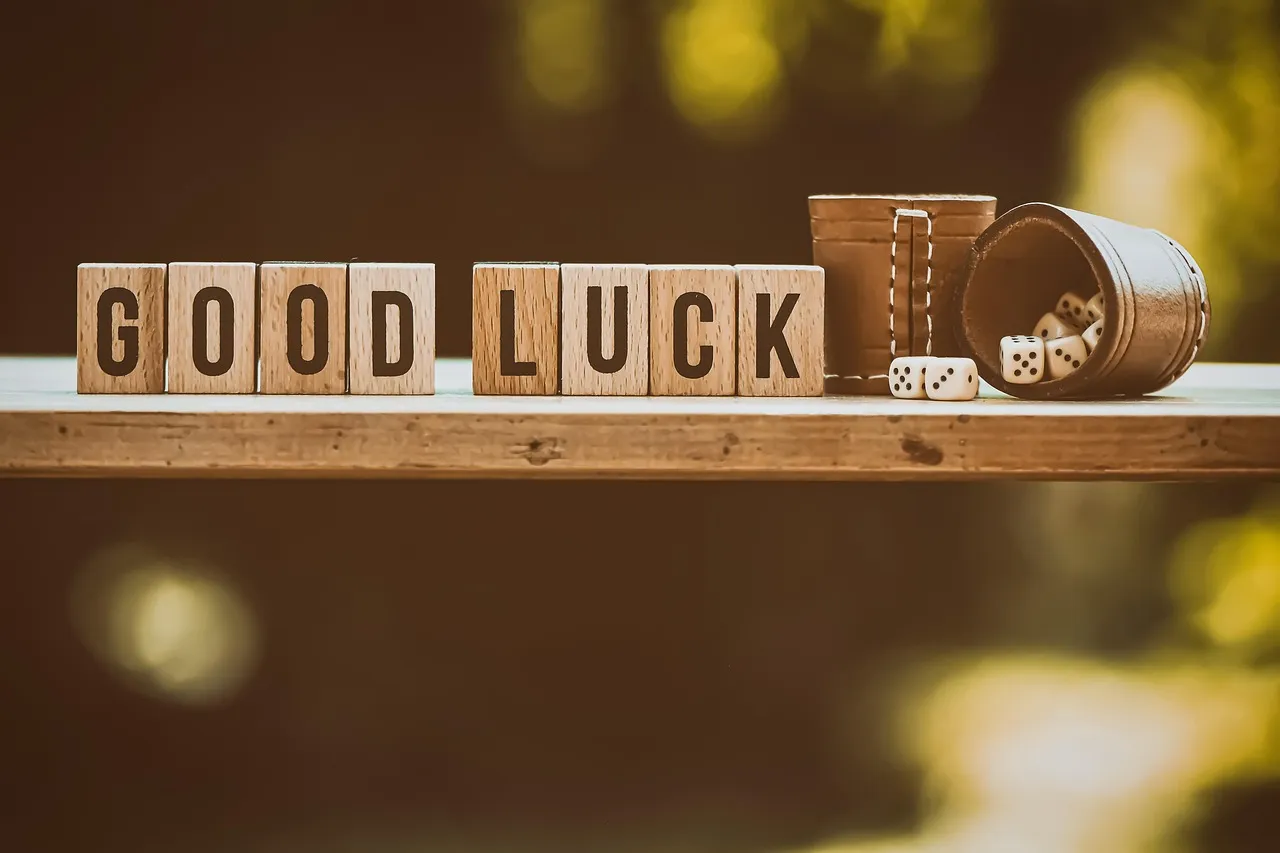 Wooden blocks spelling GOOD LUCK sit beside dice and a tipped container on a shelf.